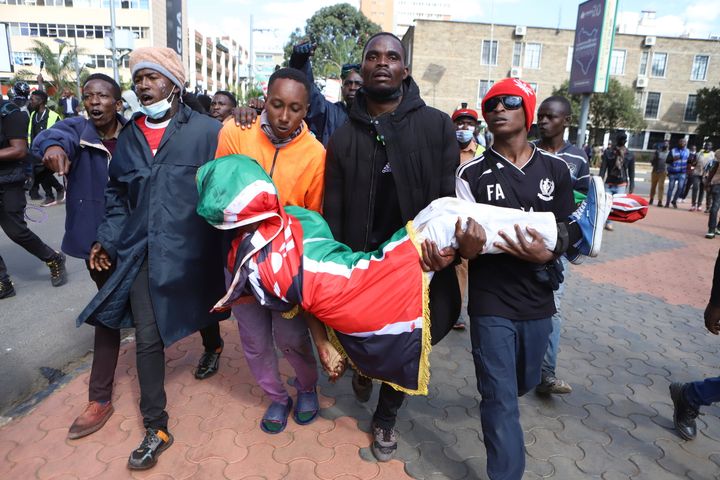 Οι διαδηλωτές μεταφέρουν το σώμα ενός άνδρα που πυροβολήθηκε κατά τη διάρκεια διαμαρτυρίας για τις προτεινόμενες αυξήσεις φόρων σε ένα νομοσχέδιο στο κέντρο του Ναϊρόμπι της Κένυας Τρίτη, 25 Ιουνίου 2024. (AP Photo/Andrew Kasuku)