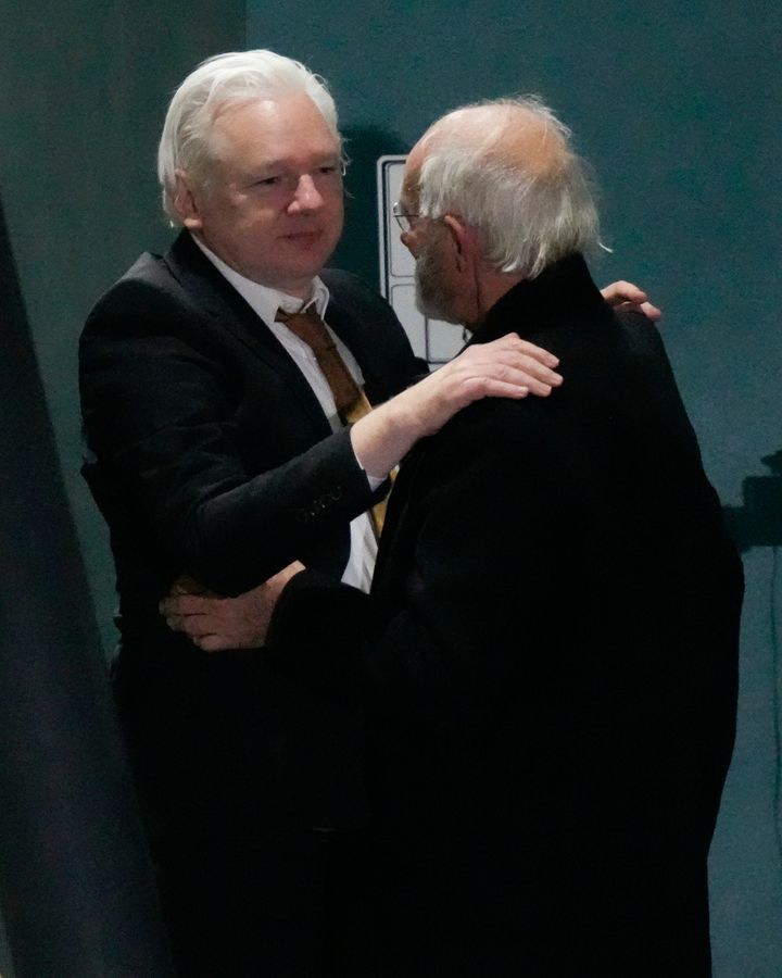 Ο ιδρυτής των WikiLeaks Τζούλιαν Ασάνζ, αριστερά, αγκαλιάζει τον πατέρα του Τζον Σίπτον κατά την άφιξή του στην αεροπορική βάση Fairbairn της RAAF στην Καμπέρα της Αυστραλίας, Τετάρτη 26 Ιουνίου 2024