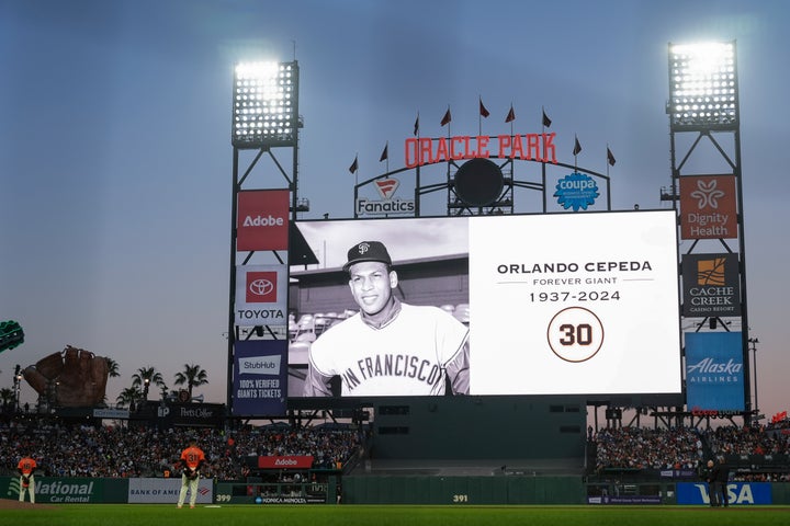 Players stand on the field as the San Francisco Giants announce the death of former baseball player Orlando Cepeda, before the sixth inning of the team's baseball game against the Los Angeles Dodgers, Friday, June 28, 2024, in San Francisco. (AP Photo/Godofredo A. Vásquez)