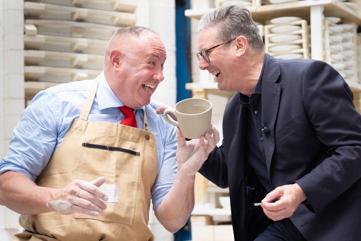 Keir Starmer laughs with celebrity potter Keith Brymer Jones during his visit to Duchess China in Longton near Stoke-On-Trent.