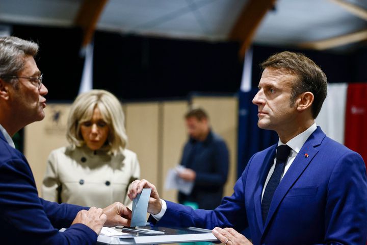 French President Emmanuel Macron, right, casts his ballot to vote in the first round of the early French parliamentary election, in Le Touquet-Paris-Plage, northern France, Sunday, June 30, 2024. (Yara Nardi, Pool via AP)