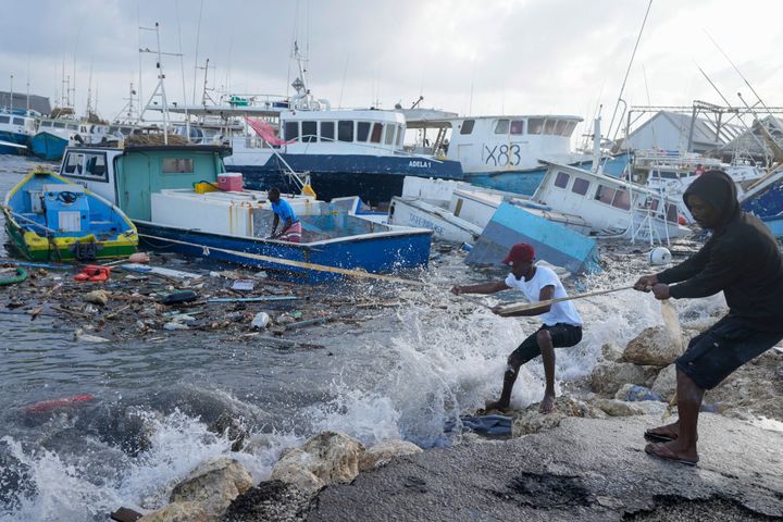 Fishermen pull a boat damaged by Hurricane Beryl back to the dock at the Bridgetown Fisheries in Barbados, on July 1, 2024. 