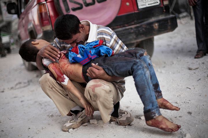 Άνδρας κλαίει έχοντας αγκαλιά τον άψυχο κορμί του γιου του. Αλέπο, Συρία 3 Οκτωβρίου 2012. 
