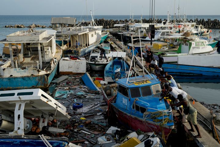 Ψαράδες σπρώχνουν μια βάρκα που υπέστη ζημιές από τον τυφώνα Beryl στο Bridgetown, Μπαρμπάντος, Τρίτη 2 Ιουλίου 2024.