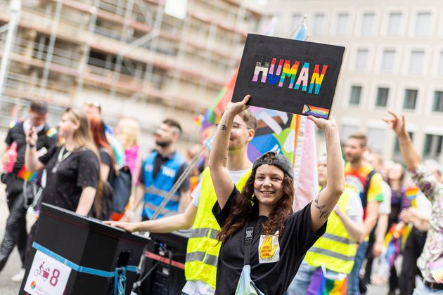 ドイツ・ハノーファーで行われたクリストファー・ストリート・デーのパレード。LGBTQ当事者の権利擁護を求め、レインボーやトランスカラーで「ヒューマン」と書かれたプラカードを掲げる参加者（2024年5月18日）
