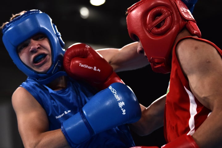 Abdumalik Khlokov of Uzbekistan, in red, fighting Ukraine's Maksym Halinichev, in blue, during the 2018 Youth Olympic Games in Argentina.