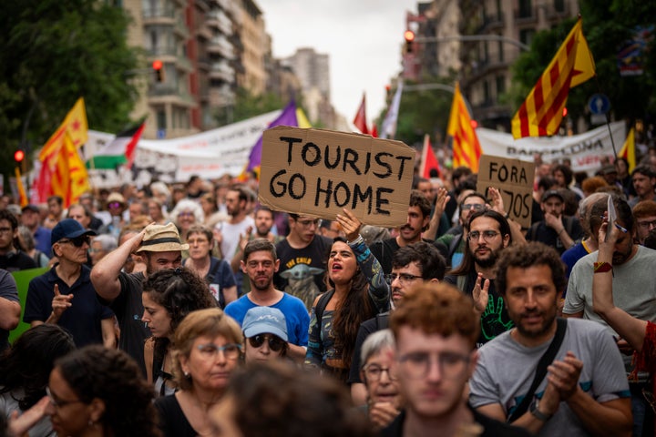Demonstrators march and shout slogans on June 19 in protest of the Formula One Barcelona Fan Festival in downtown Barcelona. About 500 Barcelona residents protested mass tourism at an exhibition of the Formula One cars.