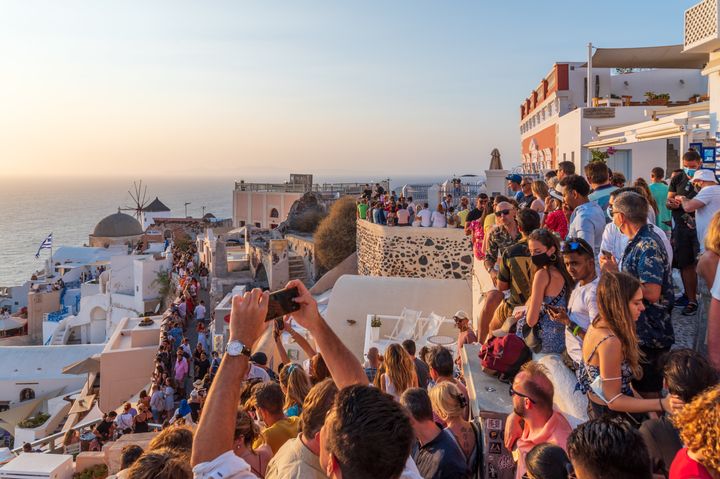 Τουρίστες στην Οία φωτογραφίζουν το ηλιοβασίλεμα