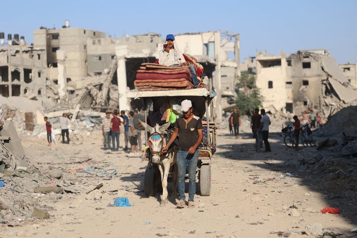 A Palestinian man leads a donkey cart past destroyed buildings and rubble after the Israeli military withdrew from the Shujaiya neighborhood, east of Gaza City on July 10, 2024. Israel's army dropped thousands of leaflets over war-torn Gaza City, urging all residents to flee a heavy offensive through the main city of the besieged territory.