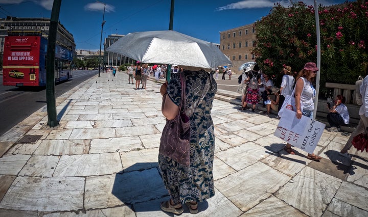 Γυναίκα με ομπρέλα στο Σύνταγμα, μπροστά από την Βουλή - Αθήνα, 11 Ιουλίου 2024.