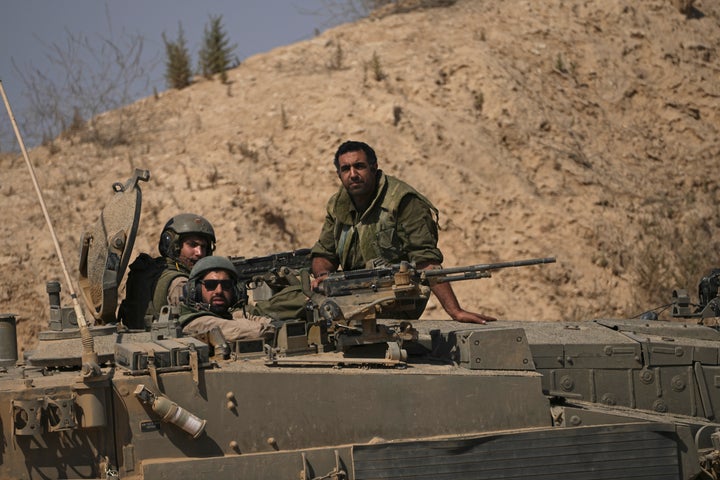 Israeli soldiers sit on their vehicle near the Israel-Gaza border in southern Israel, Friday, July 12, 2024. (AP Photo/Tsafrir Abayov)