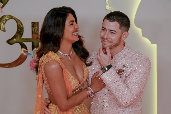 Bollywood actress Priyanka Chopra Jonas (L) and her husband American singer-songwriter and actor Nick Jonas (R) pose for photos as they arrive to attend the wedding ceremony.