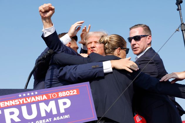 シークレットサービスに囲まれながらステージの袖に誘導されるトランプ氏BUTLER, PENNSYLVANIA - JULY 13: Republican presidential candidate former President Donald Trump is rushed offstage during a rally on July 13, 2024 in Butler, Pennsylvania. (Photo by Anna Moneymaker/Getty Images)