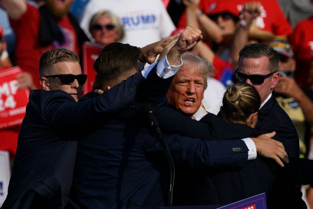 Secret Service agents surround Trump on stage.