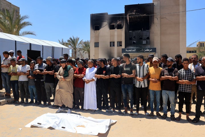 Palestinians recite a prayer over the body of a victim in front of Nasser Hospital's morgue in Khan Younis on July 13, 2024, one of the medical facilities that received victims from an Israeli strike that killed at least 90 people at the Al-Mawasi camp.