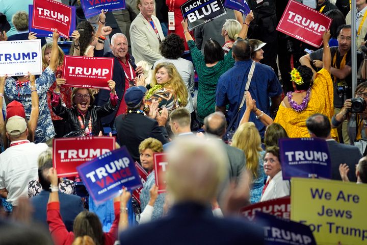 Delegates look at Republican presidential candidate former President Donald Trump, foreground, during the second day of the Republican National Convention at the Fiserv Forum, Tuesday, July 16, 2024, in Milwaukee. (AP Photo/Evan Vucci)