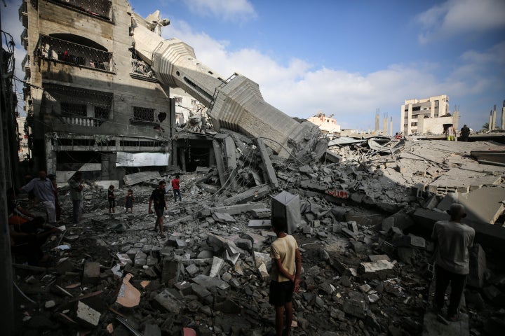 Palestinians stand on the rubble of the Abdullah Azzam Mosque, destroyed in Israeli strikes on Nuseirat, central Gaza Strip, on July 17, 2024.