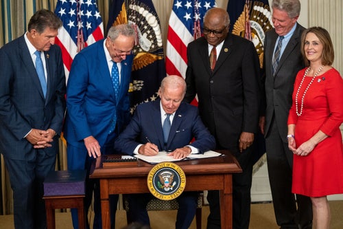President Joe Biden, flanked by Democratic lawmakers, signs the Inflation Reduction Act into law in 2022.