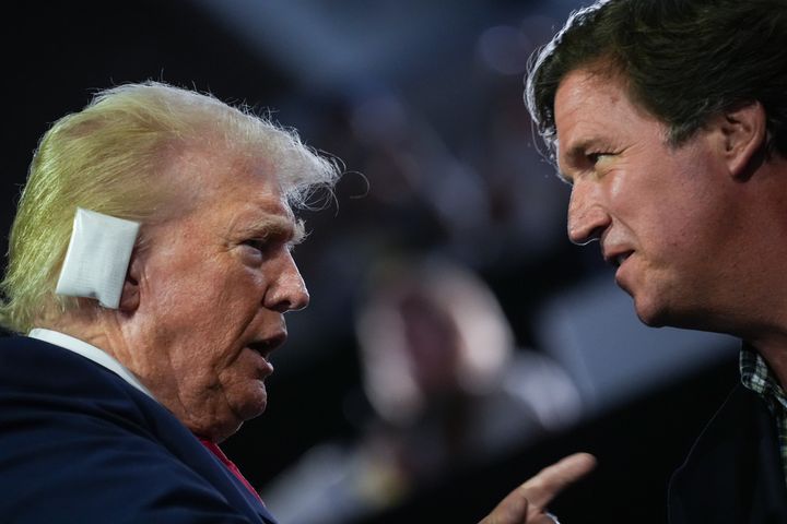 Republican presidential candidate and former President Donald Trump greets Tucker Carlson on the first day of the Republican National Convention in Milwaukee.