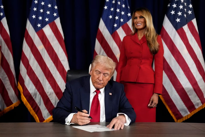 As Melania Trump watches, Republican presidential candidate former President Donald Trump signs paperwork to officially accept the nomination during the final day of the Republican National Convention at the Fiserv Forum on Thursday in Milwaukee.
