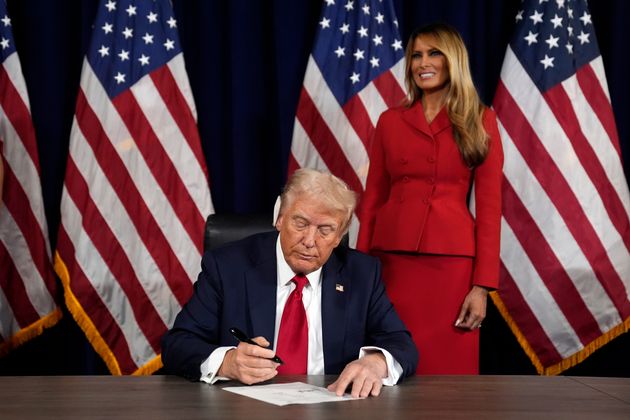 As Melania Trump watches, Republican presidential candidate former President Donald Trump signs paperwork to officially accept the nomination during the final day of the Republican National Convention at the Fiserv Forum on Thursday in Milwaukee. 