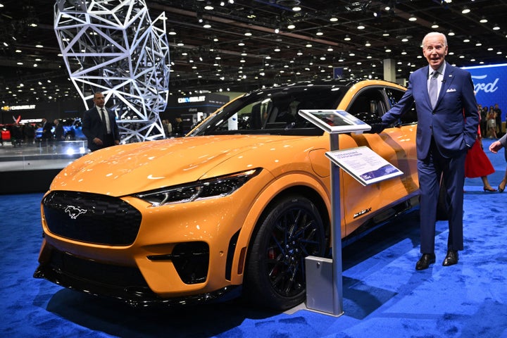 Biden looks at an electric Ford Mustang as he tours the 2022 North American International Auto Show in Detroit.