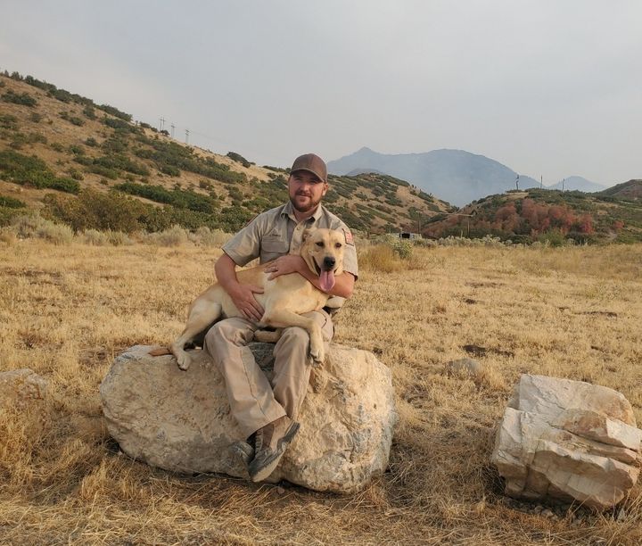 Auf dem Bild ist der Naturschutzbeauftragte James Thomas mit Kip zu sehen, dem Suchhund, der eine entscheidende Rolle bei der Rettung einer Frau in Utah spielte.