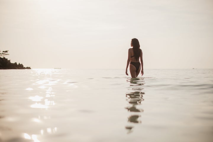 A young woman enjoys a summer day in the sea.