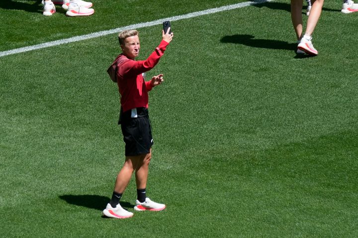 Coach Beverly Priestman of Canada takes photos on the pitch at Geoffroy-Guichard Stadium ahead of the 2024 Summer Olympics.