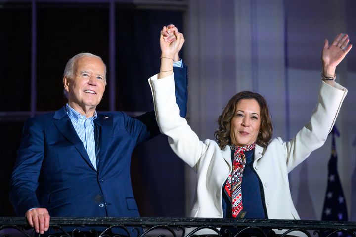 President Joe Biden and Harris raise their arms as guests cheer after watching the Independence Day fireworks from the White House in Washington, D.C., on July 4.