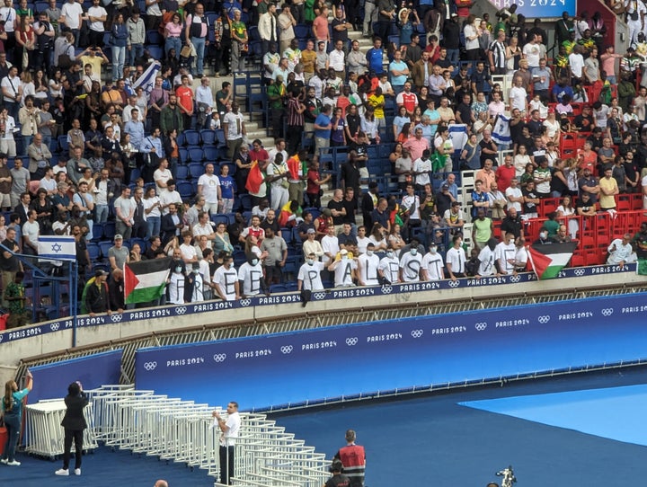 Fans open Palestinian flags and wear t-shirts with letters reading "Free Palestine" at the match between Mali and Israel.