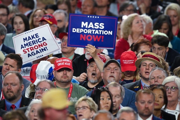 A person holds a sign that reads "Mass Deportation Now" and "Make America Strong Again" on the third day of the Republican National Convention at the Fiserv Forum on July 17, 2024 in Milwaukee, Wisconsin. 