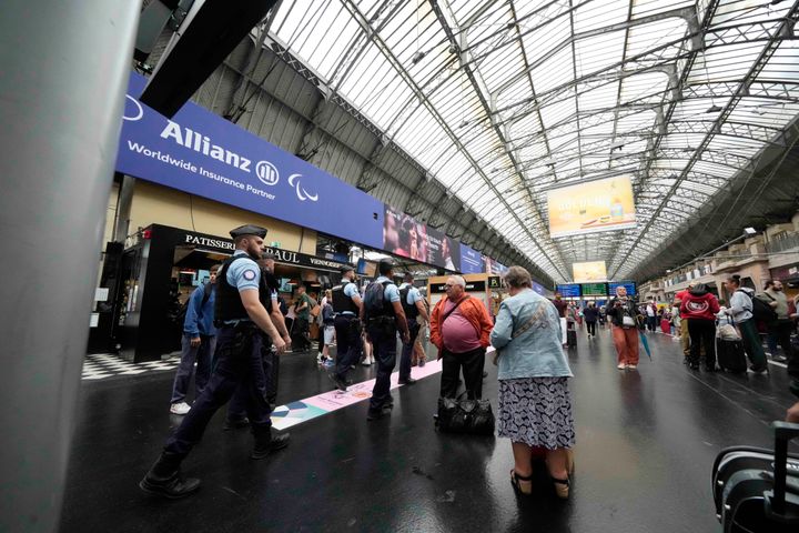 Policemen patrol the Gare de L'Est at the 2024 Summer Olympics, Friday, July 26, 2024, in Paris, France. Hours away from the grand opening ceremony of the Olympics, high-speed rail traffic was severely disrupted. (AP Photo/Luca Bruno)