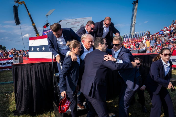 Butler, PA - July 13 : U.S. Secret Service agents remove Republican presidential candidate former president Donald Trump from the stage with blood on his face during a campaign rally at Butler Farm Show Inc. in Butler, PA on Saturday, July 13, 2024. Trump later shared that a bullet pierced part of his ear during the assassination attempt. (Photo by Jabin Botsford/The Washington Post via Getty Images)