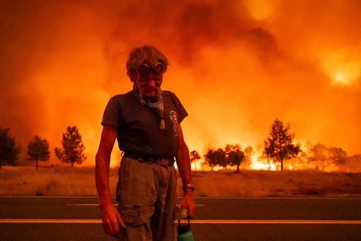 Grant Douglas pauses while evacuating as the Park Fire jumps Highway 36 near Paynes Creek in Tehama County, California, on Friday, July 26, 2024.