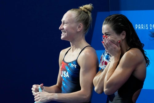Sarah Bacon, left, and Kassidy Cook react after competing in the women's synchronized 3-meter springboard event in Paris.