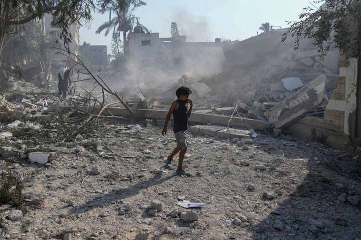 A Palestinian boy walks past the rubble of a school destroyed in an Israeli airstrike on Deir al-Balah, central Gaza Strip, Saturday, July 27, 2024. (AP Photo/Abdel Kareem Hana)