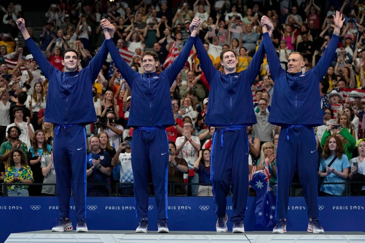 The United States men's 4x100-meter freestyle relay team celebrates on the podium after winning the gold medal at the 2024 Summer Olympics, Saturday, July 27, 2024, in Nanterre, France.