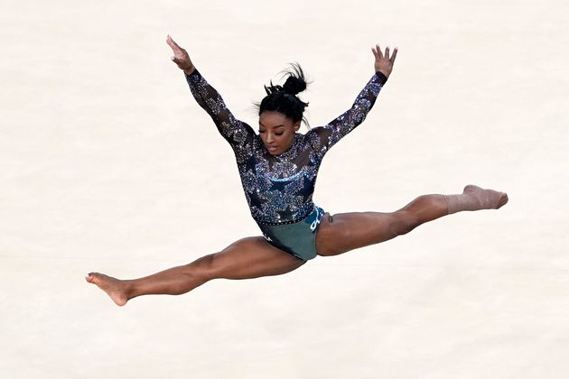 Biles competes in the floor exercise after appearing to hurt her lower leg as she landed from a tumbling sequence during practice.