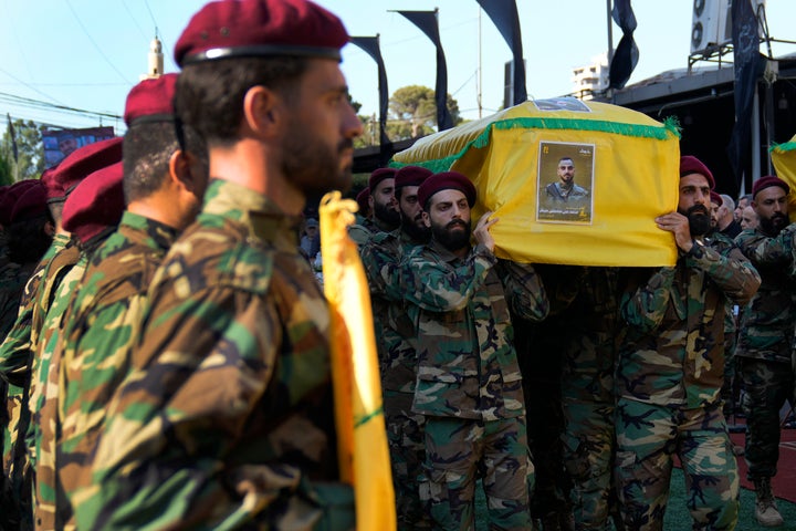 Hezbollah fighters carry the coffin of their comrade who was killed with three other fighters on Saturday by an Israeli airstrike in south Lebanon, during their funeral procession in a southern suburb of Beirut, Lebanon, Sunday, July 28, 2024.