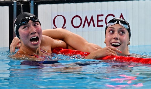 Torri Huske, left, catches sight of her victory on the scoreboard with second-place finisher Gretchen Walsh.