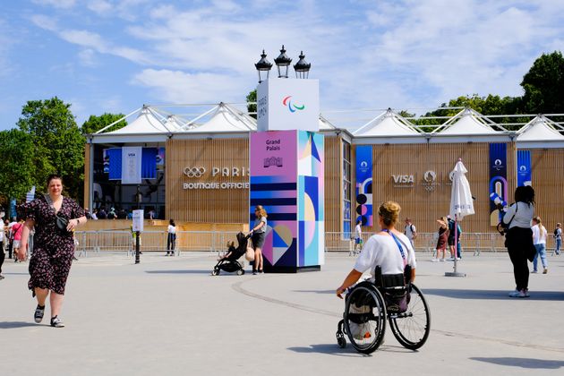 A wheelchair user, a member of the Paris Olympics staff, is seen by the official store located in front of the Grand Palais in Paris on July 28.