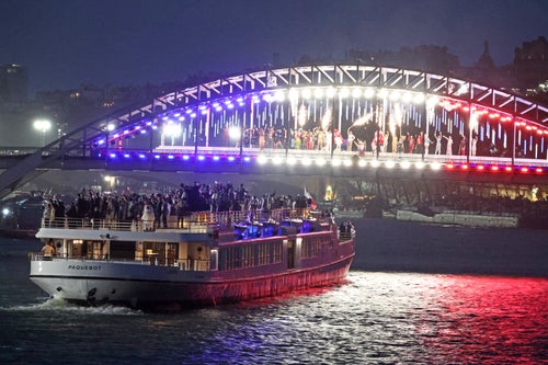 A boat carries members of a delegation along the Seine river during the opening ceremony of the Olympic Games in Paris.