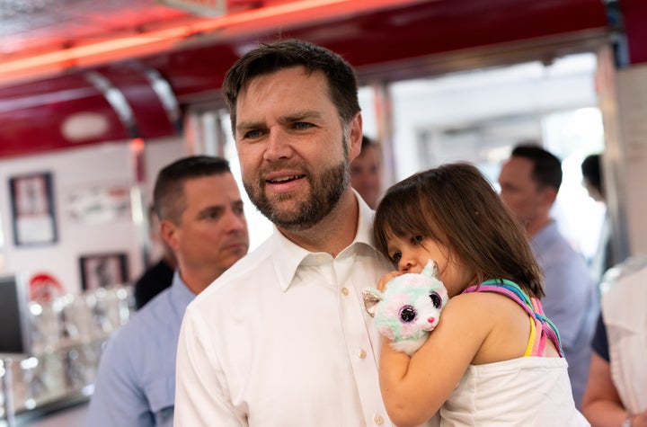 Republican vice presidential nominee Sen. JD Vance (Ohio) carries his daughter Maribel as he greets supporters at the Park Diner on July 28, 2024 in St. Cloud, Minnesota.