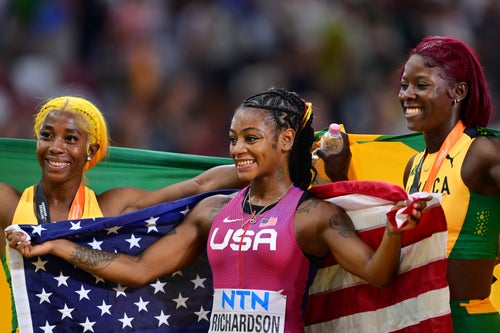 Sha'Carri Richardson celebrated her 2023 100-meter world title over Jamaican sprinters Shelly-Ann Fraser-Pryce, left, and Shericka Jackson, right.