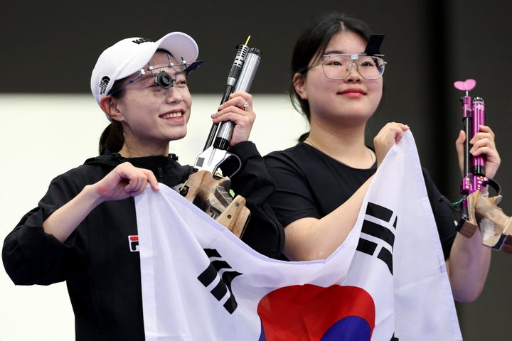 Kim and gold medalist Oh Ye Jin hold the South Korean flag as they celebrate medaling in the 10-meter air pistol women's final.