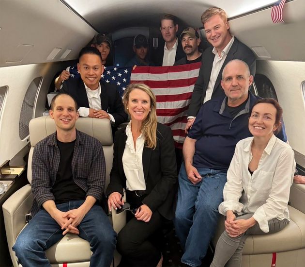 This image released by the White House shows Evan Gershkovich (left) Alsu Kurmasheva (right), Paul Whelan (second from right) and others aboard a plane Thursday after their release from Russian captivity.