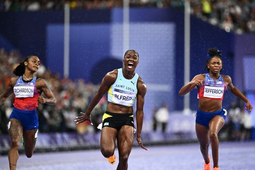 Saint Lucia's Julien Alfred (C) celebrates after winning ahead of US' Sha'Carri Richardson (L) and US' Melissa Jefferson (R) in the women's 100m final of the athletics event at the Paris 2024 Olympic Games at Stade de France in Saint-Denis, north of Paris, on August 3, 2024. (Photo by Jewel SAMAD / AFP) (Photo by JEWEL SAMAD/AFP via Getty Images)