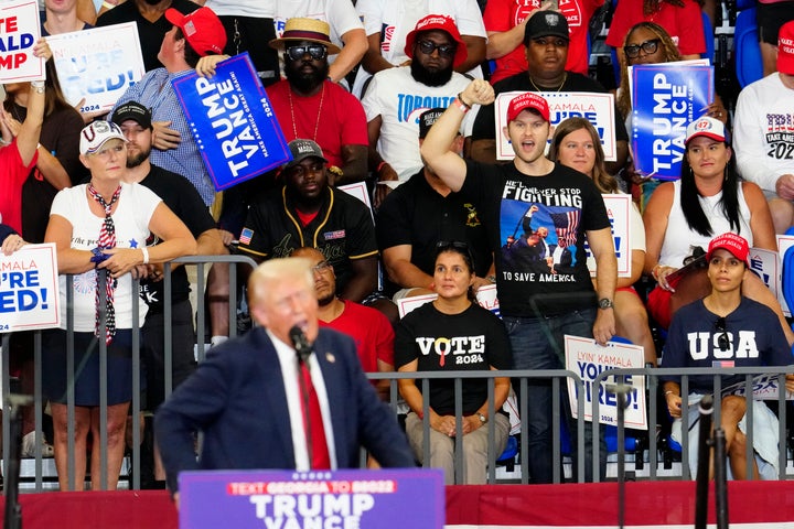 Unterstützer hören zu, wie der ehemalige republikanische Präsidentschaftskandidat Donald Trump am Samstag, den 3. August 2024, bei einer Wahlkampfveranstaltung an der Georgia State University in Atlanta spricht. (AP Photo/Ben Gray)