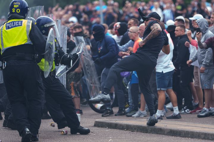 Riot police officers push back anti-migration protesters outside the Holiday Inn Express Hotel which is housing asylum seekers on August 4, 2024